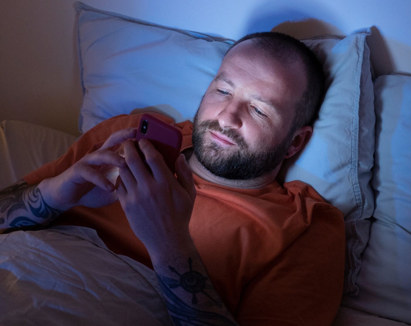Homem sem dormir usando o celular na cama